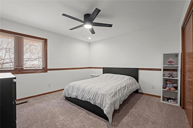 carpeted bedroom with a ceiling fan and baseboards