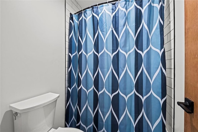 bathroom with toilet and curtained shower