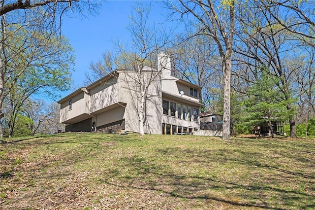 view of side of property featuring a lawn and a chimney