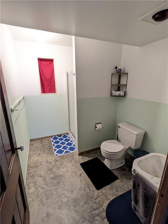 301 S 6th St, Hiawatha, KS 66434 - bathroom featuring toilet, baseboards, and a shower stall