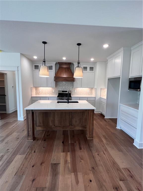 16372 Spring Valley St, Gardner, KS 66030 - kitchen with premium range hood, white cabinets, a kitchen island with sink, stainless steel appliances, and a sink