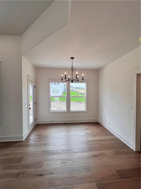 16372 Spring Valley St, Gardner, KS 66030 - unfurnished dining area with a chandelier, hardwood / wood-style floors, and baseboards