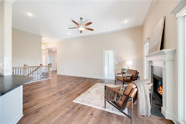 9331 N Belton Ave, Kansas City, MO 64154 - living room featuring a ceiling fan, crown molding, wood finished floors, a glass covered fireplace, and recessed lighting