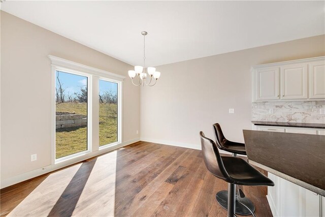 9331 N Belton Ave, Kansas City, MO 64154 - dining room with baseboards, wood finished floors, and a chandelier