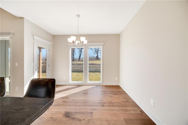 9331 N Belton Ave, Kansas City, MO 64154 - unfurnished dining area with baseboards, wood finished floors, and a notable chandelier