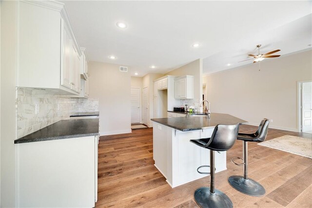 9331 N Belton Ave, Kansas City, MO 64154 - kitchen featuring a sink, decorative backsplash, a breakfast bar, and dark countertops