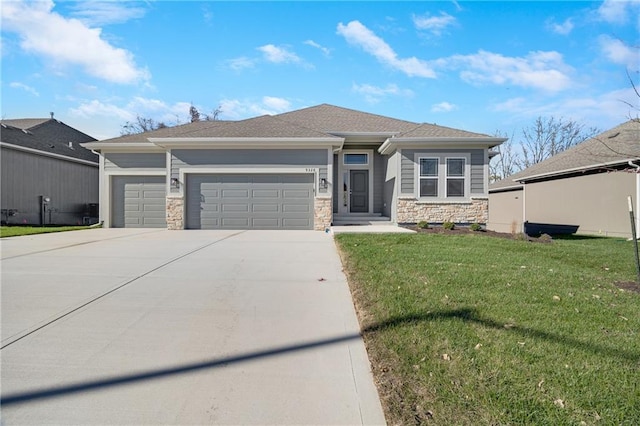 9335 N Belton Ave, Kansas City, MO 64154 - prairie-style home featuring an attached garage, concrete driveway, a front lawn, and stone siding