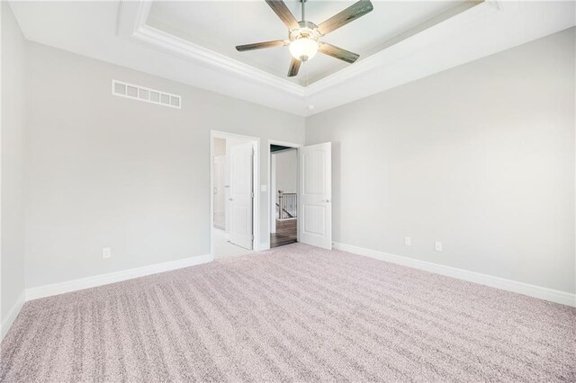 9335 N Belton Ave, Kansas City, MO 64154 - unfurnished bedroom with light colored carpet, crown molding, visible vents, a raised ceiling, and baseboards