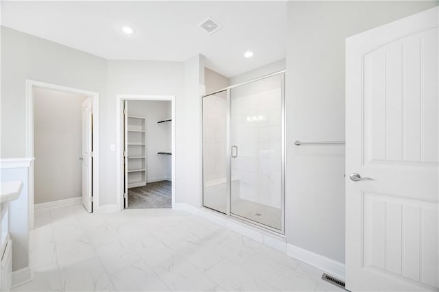 9335 N Belton Ave, Kansas City, MO 64154 - bathroom with visible vents, baseboards, a walk in closet, and a stall shower