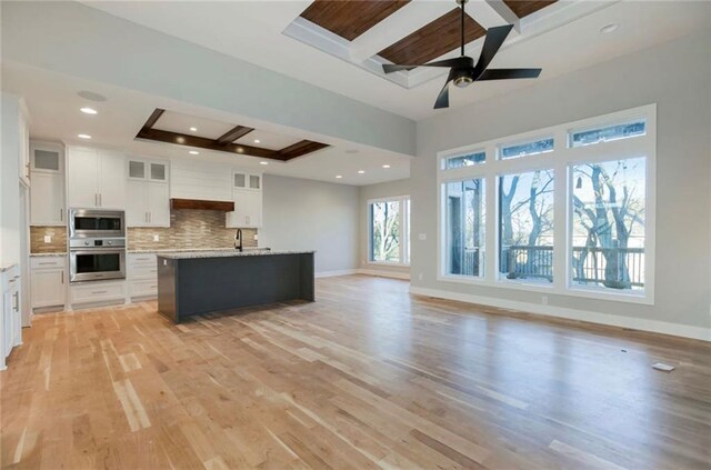3217 SW Saddlebred Ter, Lees Summit, MO 64082 - kitchen featuring appliances with stainless steel finishes, beam ceiling, backsplash, light wood finished floors, and white cabinets