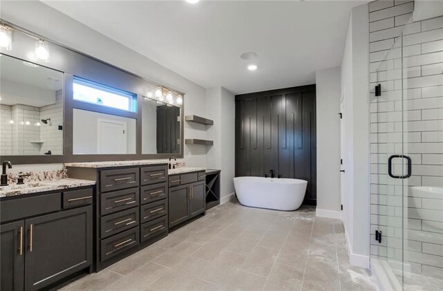 3217 SW Saddlebred Ter, Lees Summit, MO 64082 - bathroom featuring a stall shower, double vanity, a freestanding tub, baseboards, and recessed lighting