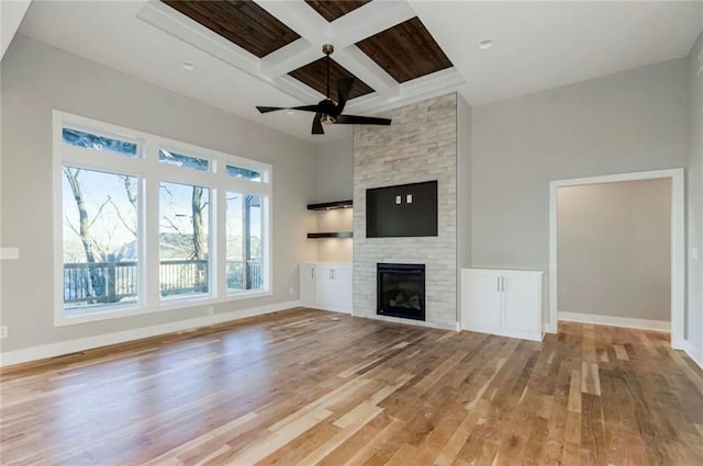 3217 SW Saddlebred Ter, Lees Summit, MO 64082 - unfurnished living room featuring light wood finished floors, beam ceiling, a fireplace, coffered ceiling, and baseboards