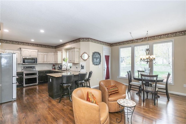 living area with recessed lighting, a notable chandelier, dark wood-style flooring, and baseboards