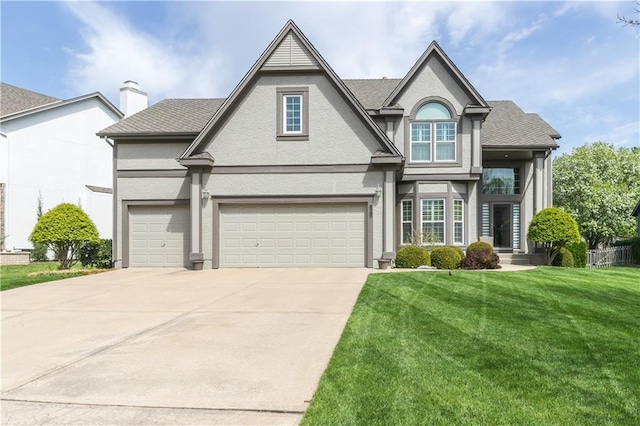 traditional-style home with stucco siding, a front yard, an attached garage, a chimney, and concrete driveway