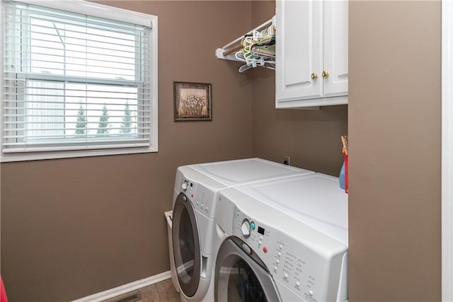 laundry area featuring tile patterned floors, washing machine and dryer, baseboards, and cabinet space