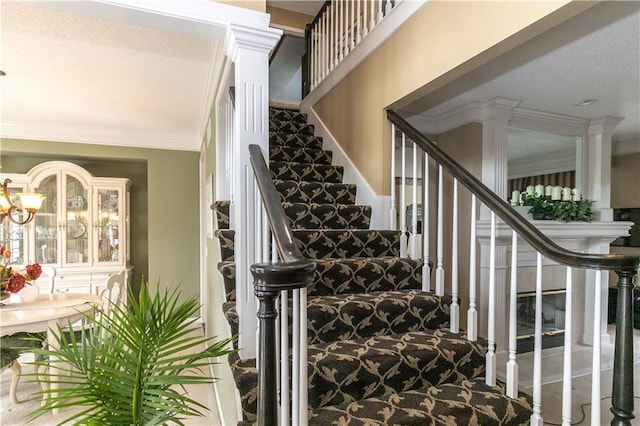 stairs with ornamental molding and ornate columns