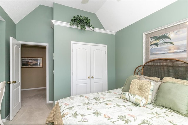 bedroom with a closet, baseboards, light colored carpet, and lofted ceiling