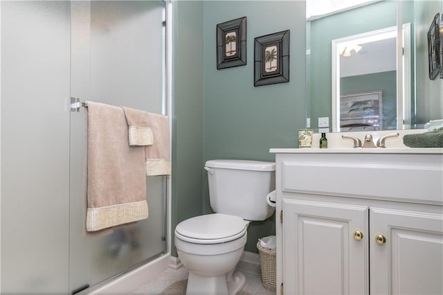 full bath with toilet, vanity, and a stall shower