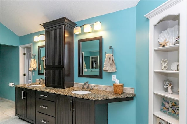 full bath featuring built in features, double vanity, vaulted ceiling, and a sink