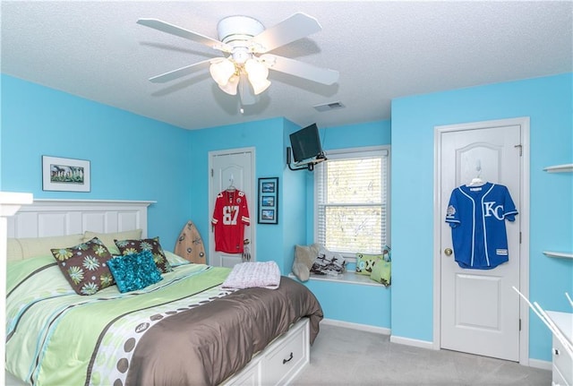 bedroom with baseboards, a textured ceiling, a ceiling fan, visible vents, and light colored carpet