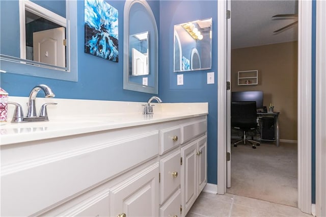 bathroom featuring double vanity, a sink, tile patterned flooring, and baseboards