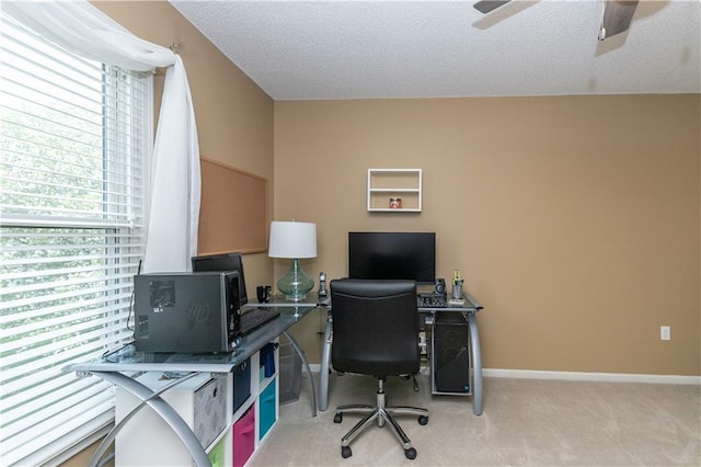 carpeted office space with baseboards, a ceiling fan, and a textured ceiling