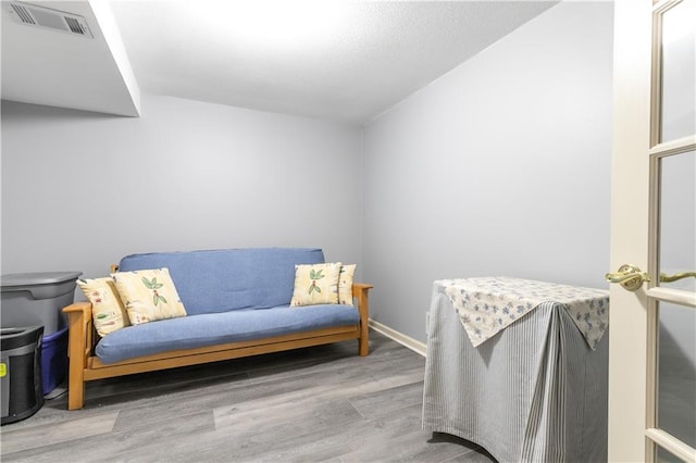living area featuring visible vents and wood finished floors