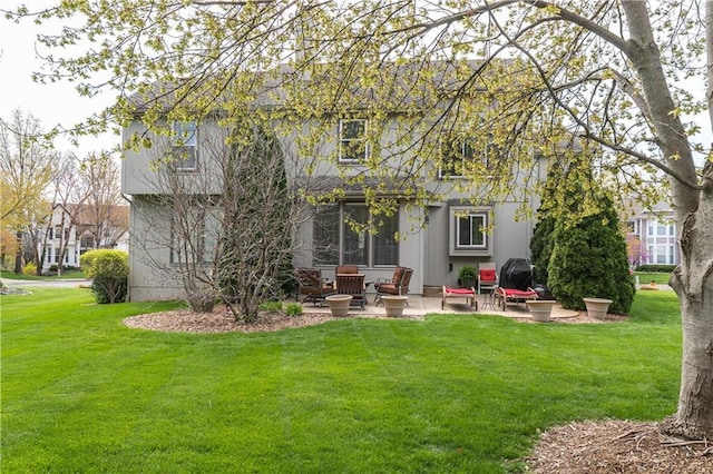 rear view of house featuring a patio and a yard