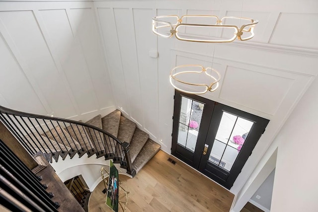 3141 SW Summit View Trl, Lees Summit, MO 64082 - entryway featuring a chandelier, a decorative wall, stairs, light wood-style floors, and french doors