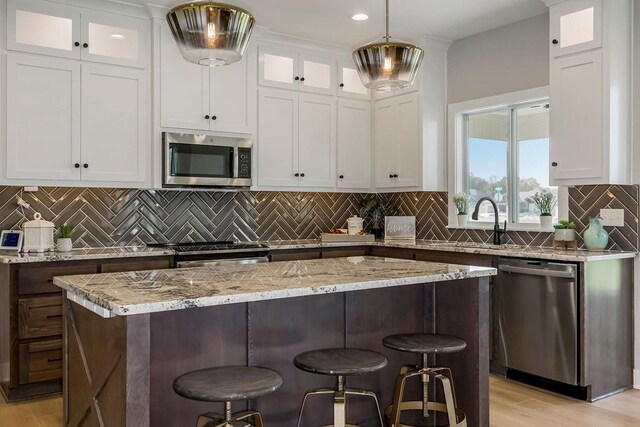 3141 SW Summit View Trl, Lees Summit, MO 64082 - kitchen with appliances with stainless steel finishes, white cabinetry, a kitchen breakfast bar, and recessed lighting