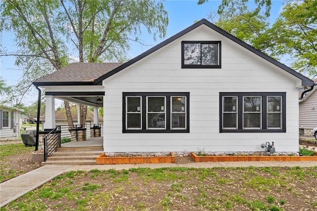 exterior space with a porch and roof with shingles