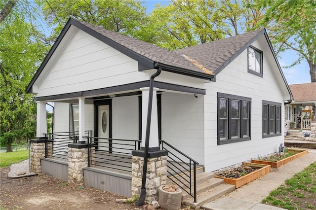 view of front of property with roof with shingles and a porch