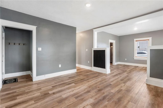 unfurnished living room with visible vents, recessed lighting, light wood-style floors, and baseboards