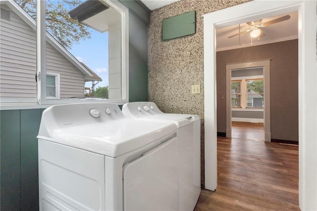 laundry room featuring crown molding, wood finished floors, washing machine and dryer, baseboards, and a ceiling fan