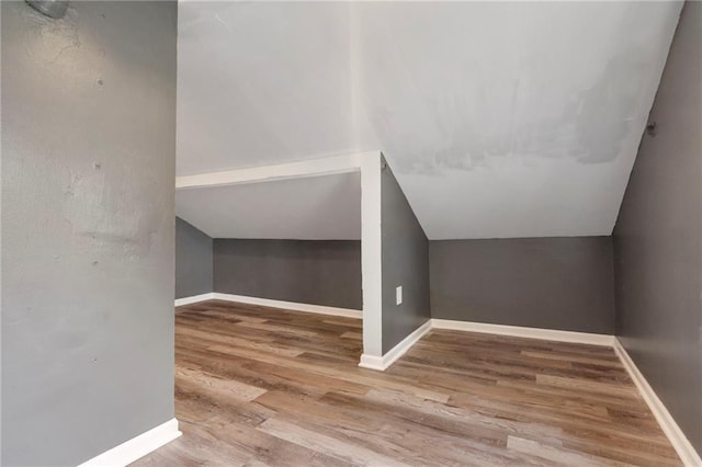 bonus room with baseboards, wood finished floors, and lofted ceiling