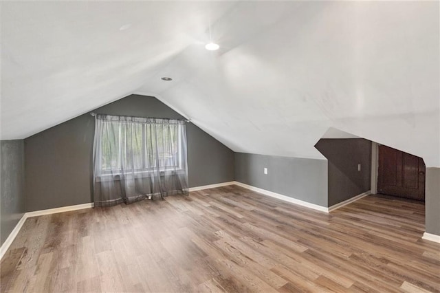 bonus room featuring wood finished floors, baseboards, and lofted ceiling