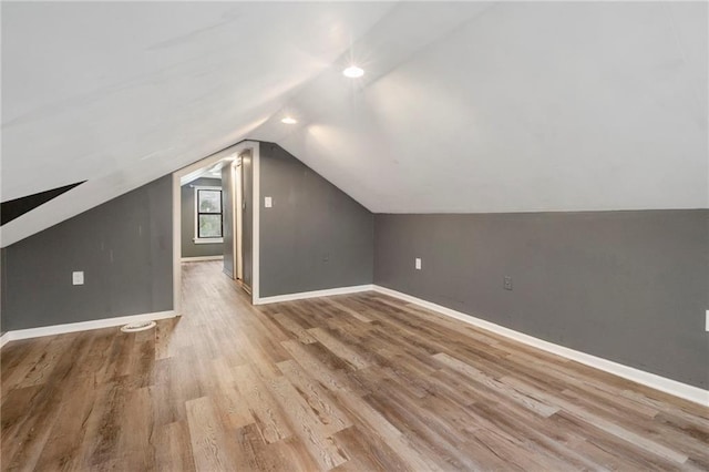 bonus room featuring baseboards, vaulted ceiling, and wood finished floors