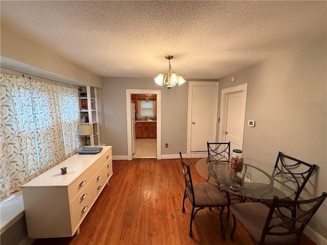 110 W Mechanic Ave, Independence, MO 64050 - dining area featuring a chandelier, a textured ceiling, dark wood-style flooring, and baseboards