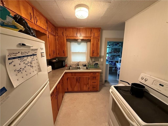 110 W Mechanic Ave, Independence, MO 64050 - kitchen featuring white appliances, brown cabinets, a sink, and light countertops