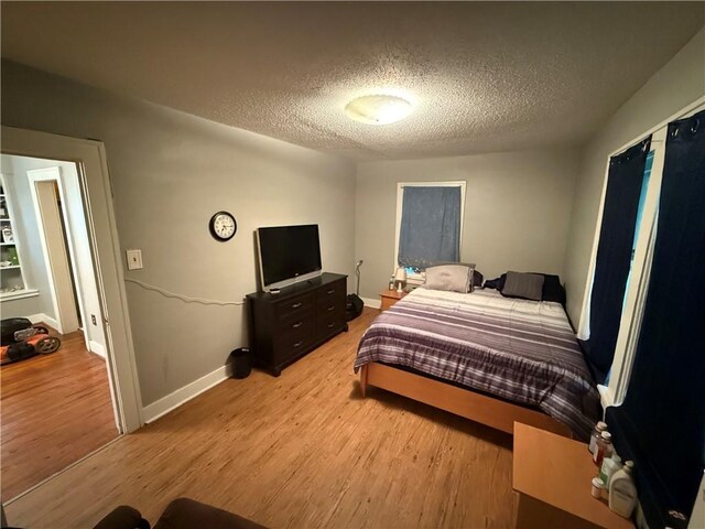 110 W Mechanic Ave, Independence, MO 64050 - bedroom featuring a textured ceiling, light wood-type flooring, and baseboards