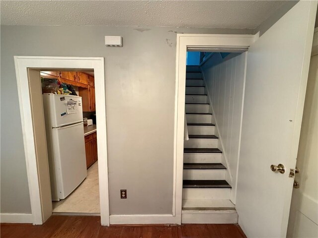 110 W Mechanic Ave, Independence, MO 64050 - stairway featuring wood finished floors, a textured ceiling, and baseboards