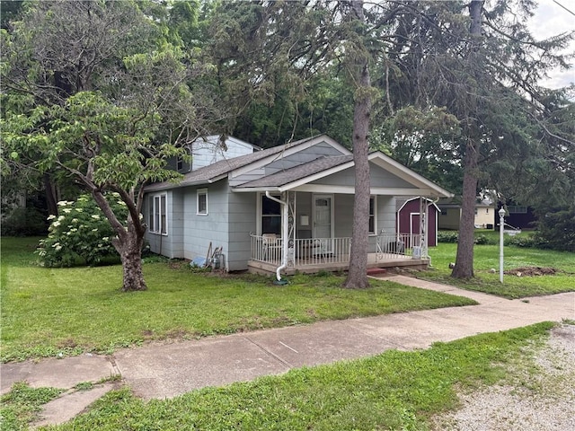 110 W Mechanic Ave, Independence, MO 64050 - bungalow featuring covered porch, a front yard, and a shingled roof