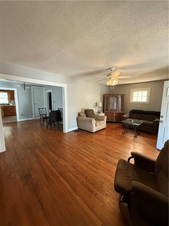 110 W Mechanic Ave, Independence, MO 64050 - living room with a textured ceiling, wood finished floors, ceiling fan, and baseboards