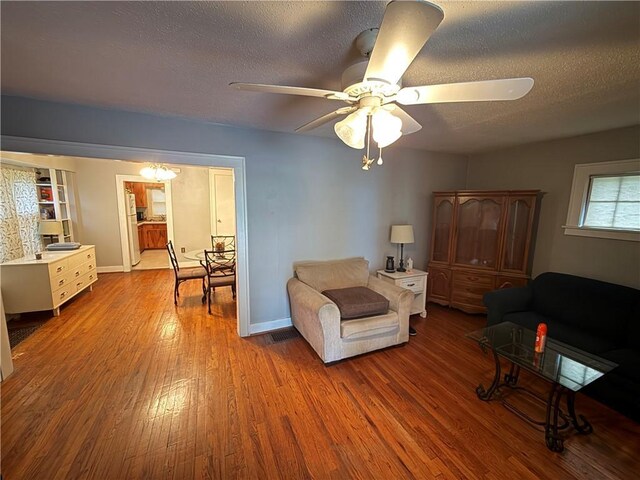 110 W Mechanic Ave, Independence, MO 64050 - living area featuring a ceiling fan, wood finished floors, a textured ceiling, and baseboards