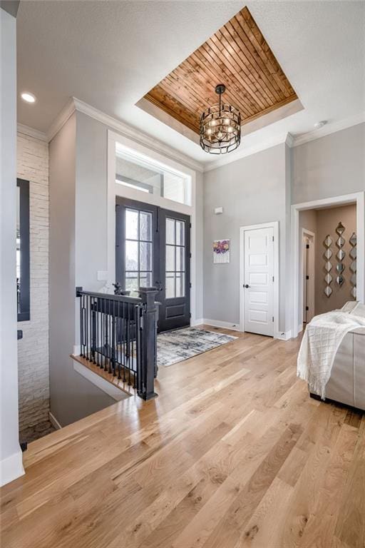 7530 N Gower Ave, Kansas City, MO 64151 - foyer featuring a raised ceiling, crown molding, baseboards, and a notable chandelier