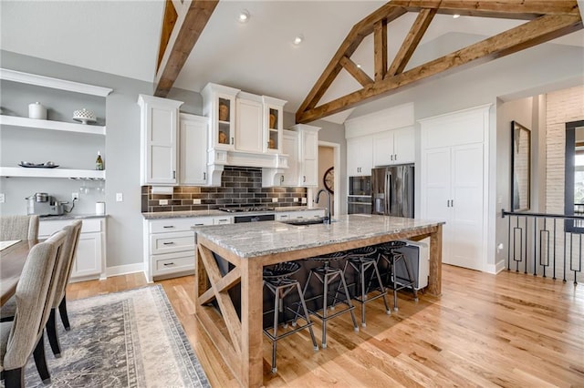7530 N Gower Ave, Kansas City, MO 64151 - kitchen with a breakfast bar, beamed ceiling, decorative backsplash, stainless steel appliances, and a sink