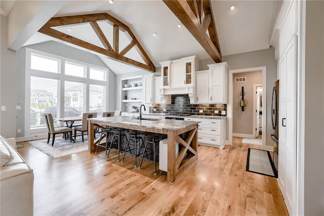 7530 N Gower Ave, Kansas City, MO 64151 - kitchen with baseboards, a sink, white cabinets, and a breakfast bar