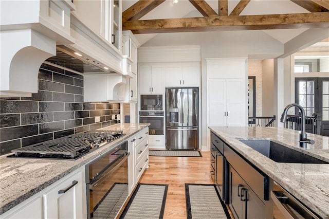 7530 N Gower Ave, Kansas City, MO 64151 - kitchen with tasteful backsplash, white cabinets, a sink, beam ceiling, and stainless steel appliances