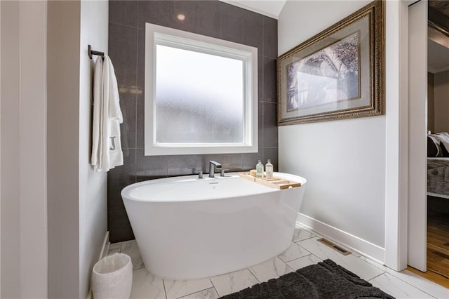 7530 N Gower Ave, Kansas City, MO 64151 - bathroom with visible vents, marble finish floor, baseboards, and a soaking tub