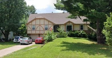 tudor home featuring a garage, concrete driveway, and a front lawn